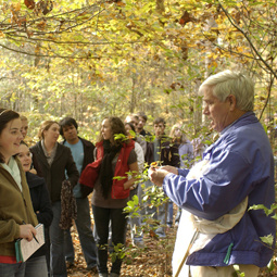 community member teaching students in forest