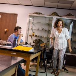 Professor and student laughing together in a classroom