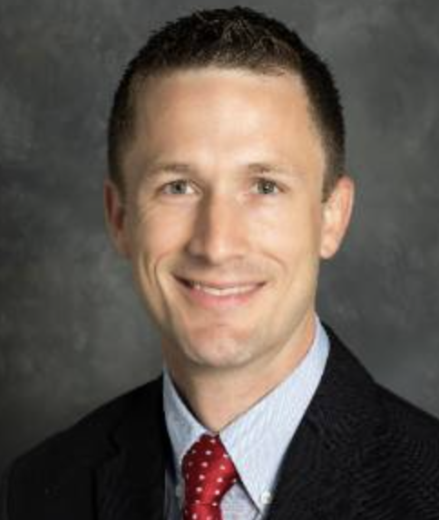 Dr. Robert Hock, a white man with short brown hair, smiles at the camera for a professional headshot.