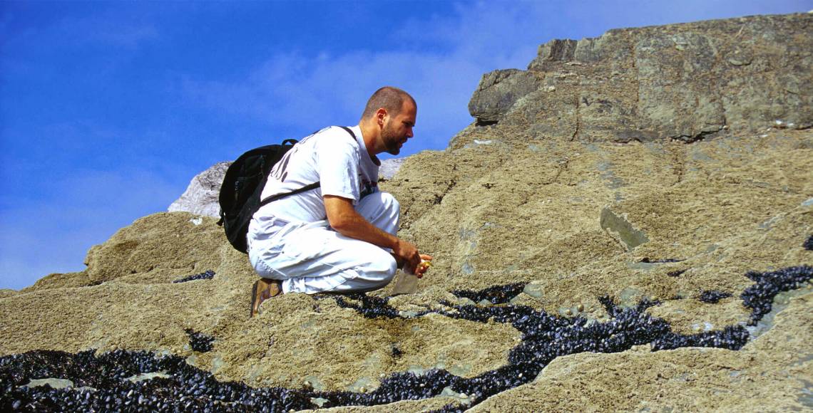 man on rocks with backpack