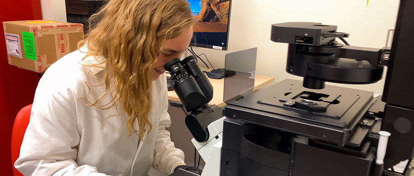 Chemistry student looking through a microscope