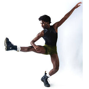 A man dancing with one leg and one arm extended