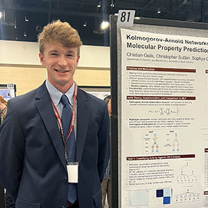 Student presenting a research poster titled “Kolmogorov-Arnold Networks for Molecular Property Prediction” at a conference.