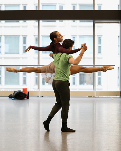 The Joffrey Ballet's Amanda Assucena and Alberto Velazquez rehearse in the studio. She is being lifted with her legs in jete position.