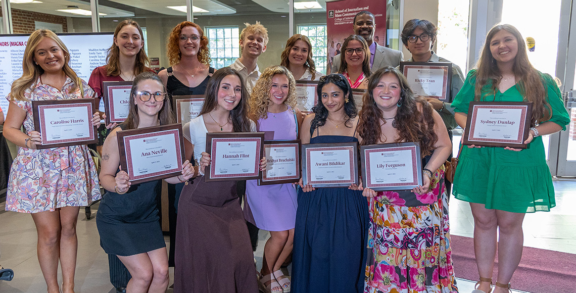 students holding awards
