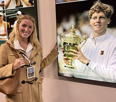 Haley Borns standing in front of a photo of a tennis champion holding a trophy