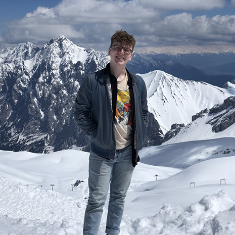 White stands in front of mountains on Maymester.