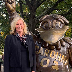 Lori Pennington-Gray standing next to a statue of Cocky.