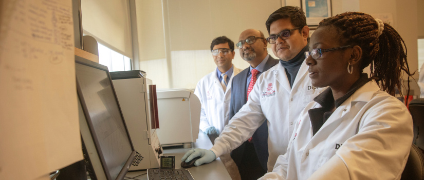 A group of people in a lab looking at a computer screen