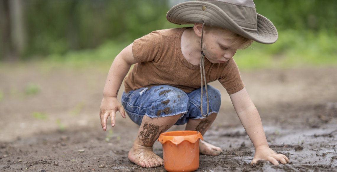 boy playing in mud