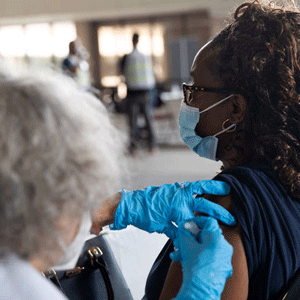 a woman receives a COVID vaccination