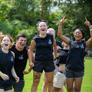 Students in black Pillars for Carolina T-shirts cheer during a field game