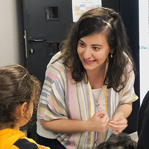 Teacher interacting with a child in classroom.