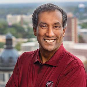 Deepal Eliatamby stands in his office with the statehouse dome in the background