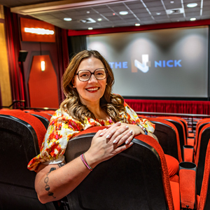 woman sits in a movie theater with the words 