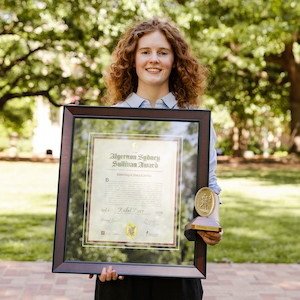 woman in blue shirt holding framed award