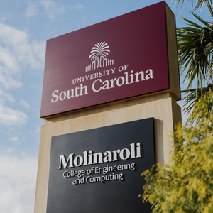 Signage of the Molinaroli College of Engineering and Computing under a garnet University of South Carolina sign